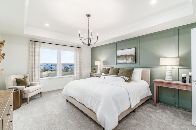 bedroom featuring a notable chandelier, light carpet, and a tray ceiling