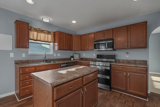 kitchen featuring a center island, sink, stainless steel appliances, and dark wood-type flooring