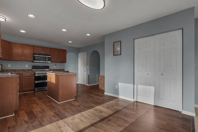 kitchen featuring a center island, stainless steel appliances, dark hardwood / wood-style floors, and sink