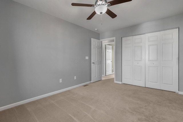 unfurnished bedroom featuring a closet, ceiling fan, and light colored carpet