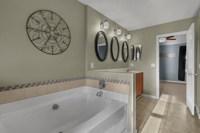 bathroom with vanity, a bathtub, and ceiling fan