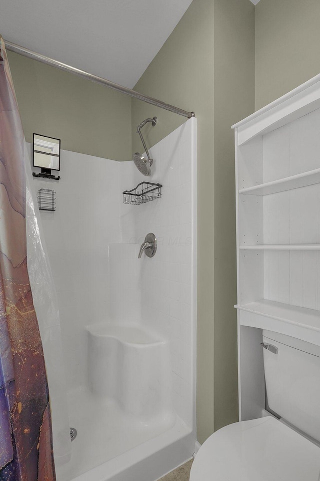 bathroom featuring toilet and a shower with shower curtain