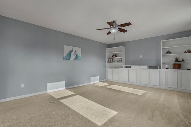 empty room with ceiling fan and light carpet