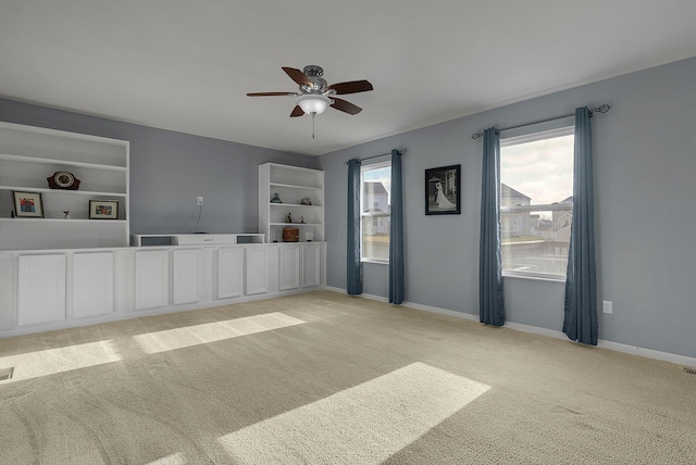 unfurnished living room with ceiling fan and light carpet