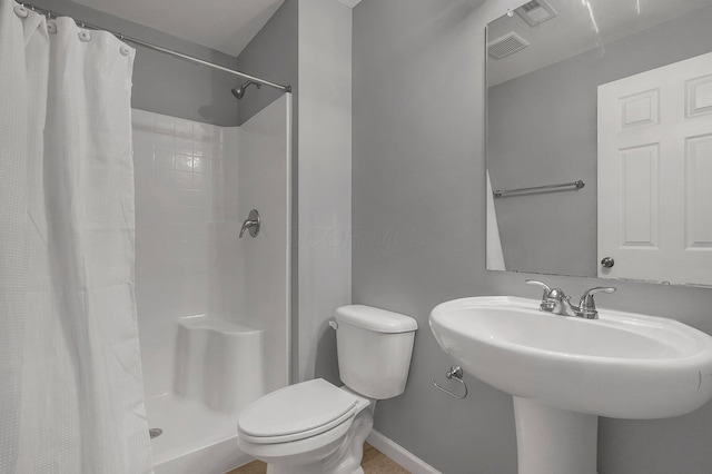 bathroom featuring sink, toilet, and walk in shower