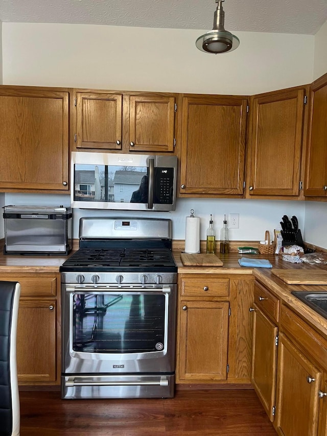 kitchen with dark wood-type flooring and appliances with stainless steel finishes