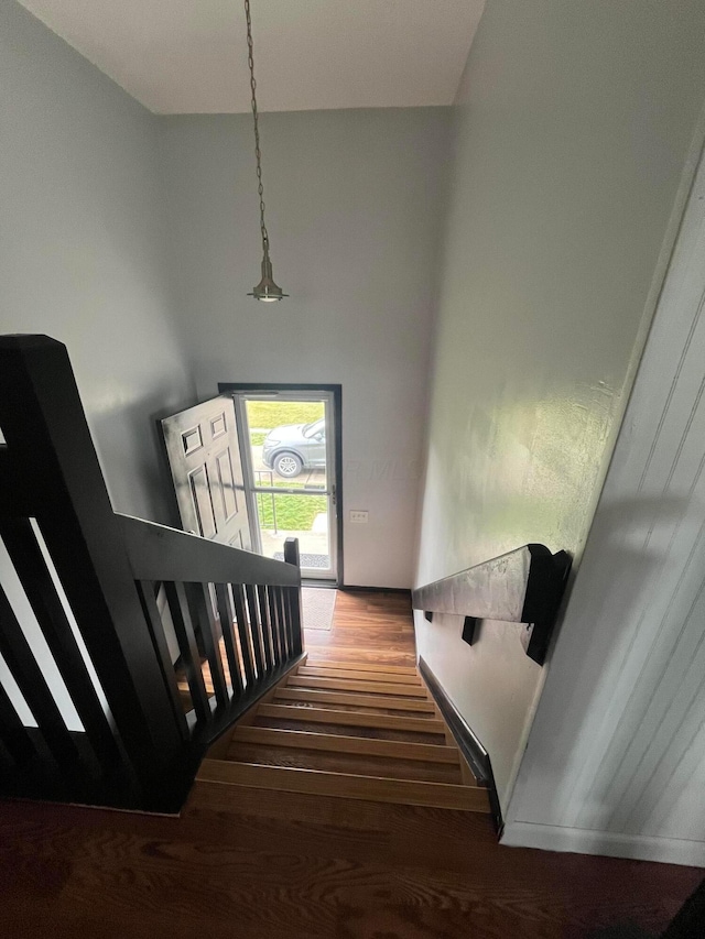 stairway featuring a high ceiling and wood-type flooring