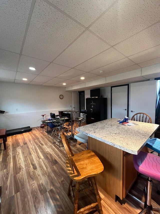 interior space featuring bar area, hardwood / wood-style floors, and a paneled ceiling