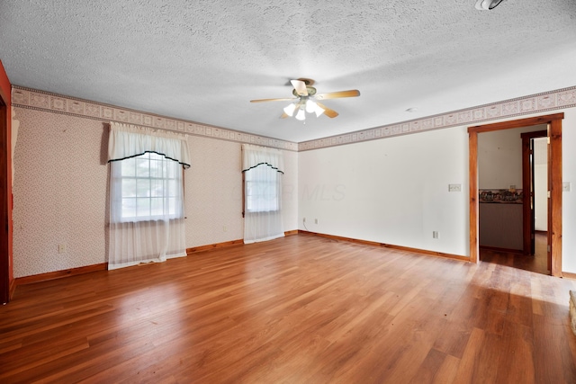 unfurnished room featuring ceiling fan, wood-type flooring, and a textured ceiling