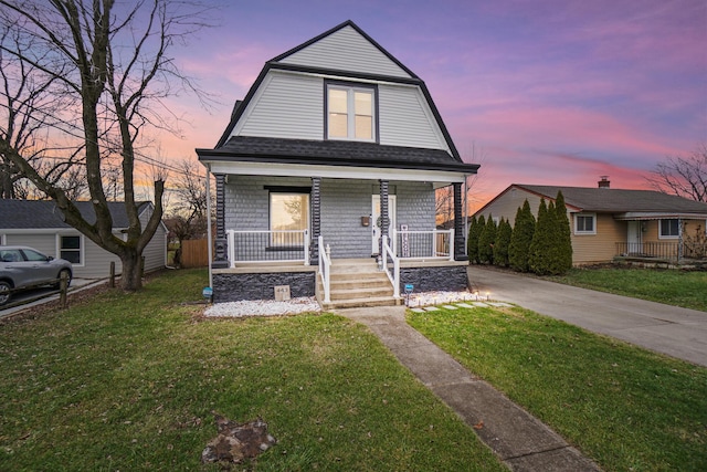 bungalow-style home with a lawn and covered porch