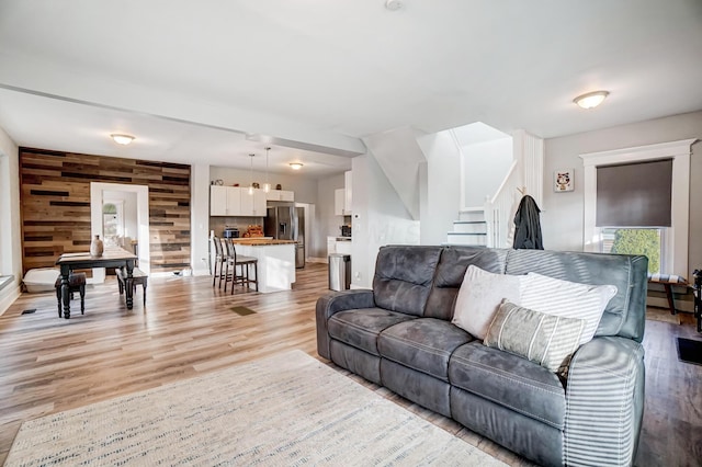 living room featuring wood walls and light hardwood / wood-style flooring