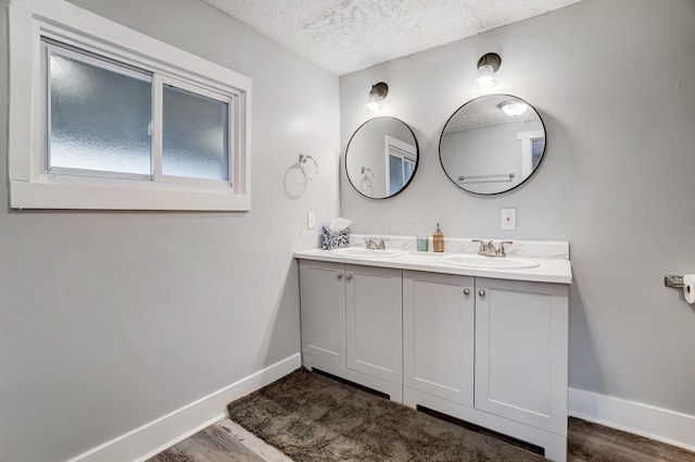 bathroom with vanity, wood-type flooring, and a textured ceiling