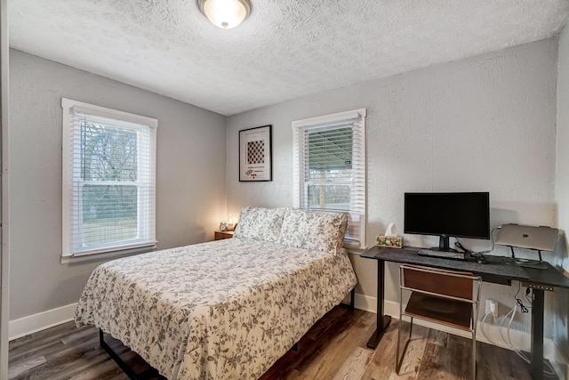 bedroom featuring dark hardwood / wood-style flooring and a textured ceiling