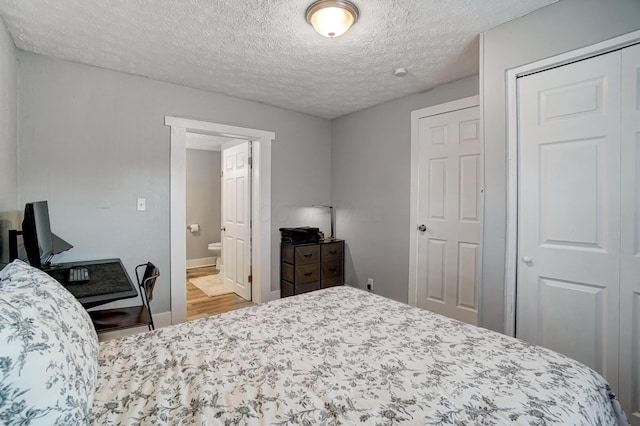 bedroom with a textured ceiling and ensuite bath