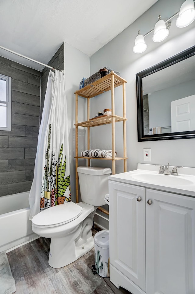 full bathroom featuring hardwood / wood-style floors, vanity, toilet, and shower / tub combo