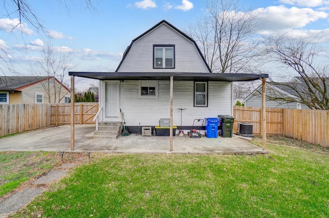 back of house with a patio, a lawn, and central air condition unit