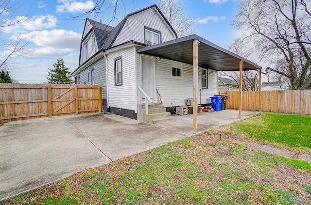 back of house featuring a lawn and a carport