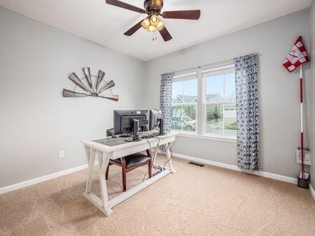 carpeted office space featuring ceiling fan