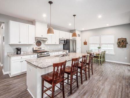 kitchen featuring white cabinetry, sink, a kitchen island with sink, and appliances with stainless steel finishes