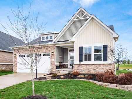 craftsman inspired home featuring a garage and a front lawn