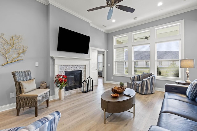 living room featuring light hardwood / wood-style flooring, ceiling fan, and crown molding