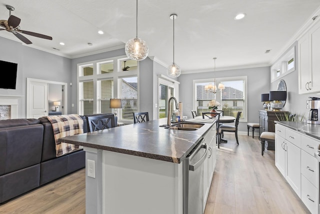 kitchen featuring a kitchen island with sink, white cabinets, sink, hanging light fixtures, and stainless steel dishwasher