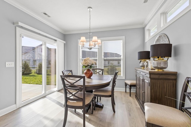 dining room featuring a chandelier, light wood-type flooring, and ornamental molding