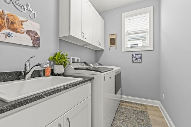 washroom featuring hardwood / wood-style floors, washer and dryer, cabinets, and sink