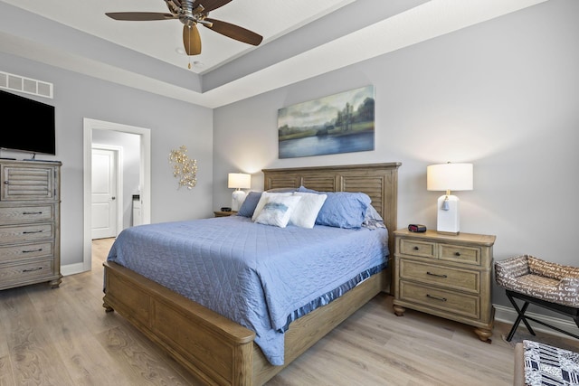 bedroom with connected bathroom, light hardwood / wood-style floors, and ceiling fan