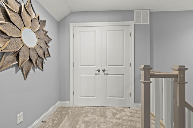 corridor with carpet floors and vaulted ceiling