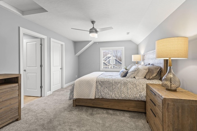 bedroom with ceiling fan, lofted ceiling, and light carpet