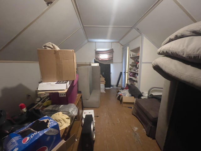 additional living space featuring hardwood / wood-style flooring, built in shelves, and lofted ceiling