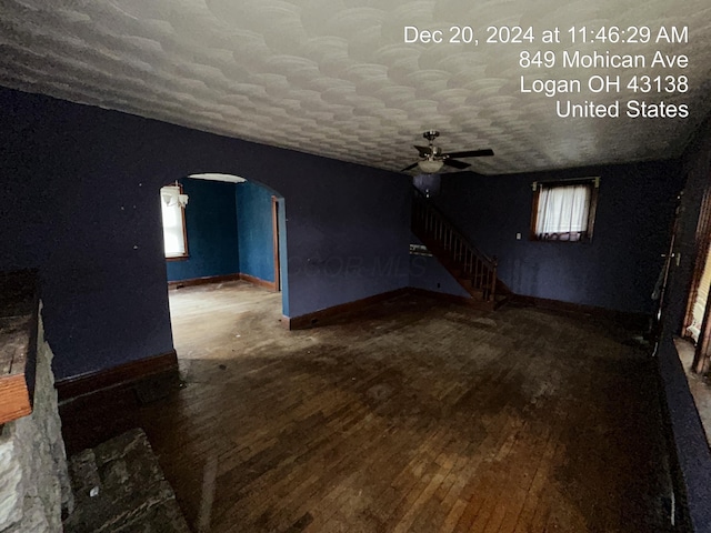 unfurnished living room with wood-type flooring, a textured ceiling, and ceiling fan