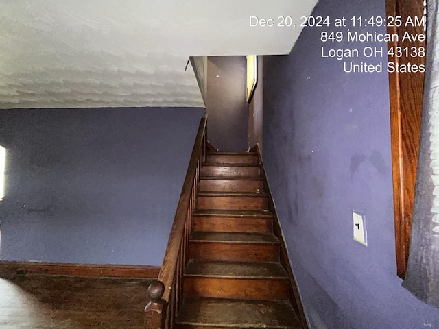 staircase with a textured ceiling