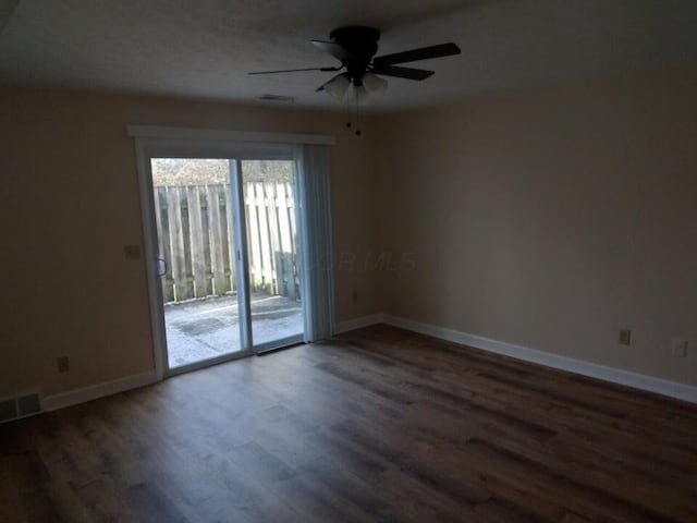 empty room featuring ceiling fan and dark wood-type flooring