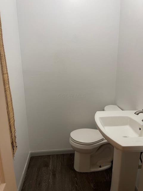 bathroom featuring toilet and wood-type flooring