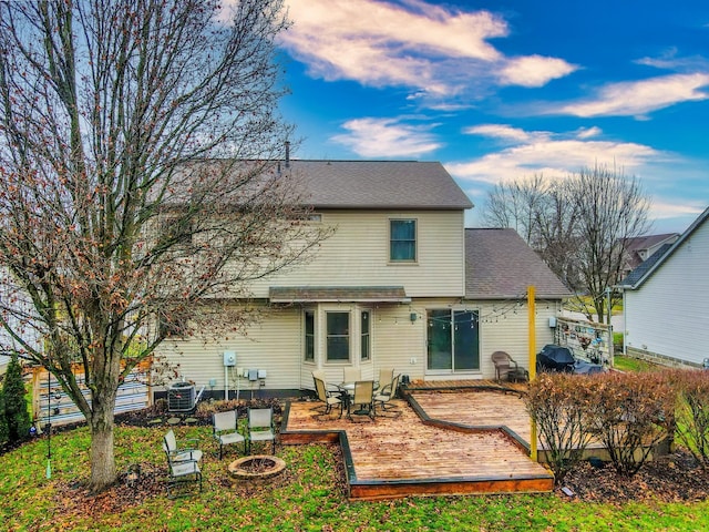 rear view of property with a wooden deck and central AC unit