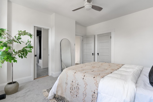 carpeted bedroom with ceiling fan and ensuite bath