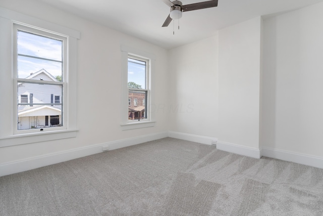 carpeted empty room with ceiling fan and a healthy amount of sunlight