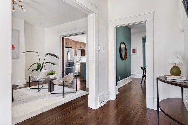 corridor with dark hardwood / wood-style floors and sink