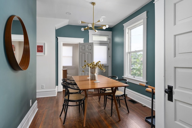 dining area featuring dark hardwood / wood-style floors and an inviting chandelier