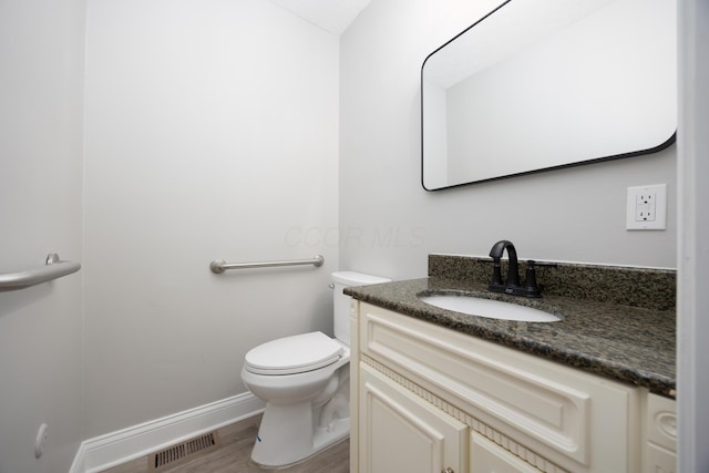 bathroom featuring hardwood / wood-style flooring, vanity, and toilet