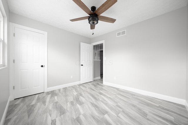 unfurnished bedroom with ceiling fan and a closet