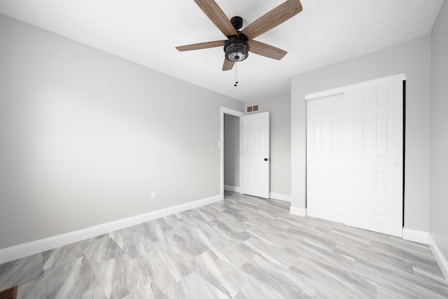 unfurnished bedroom featuring ceiling fan and a closet