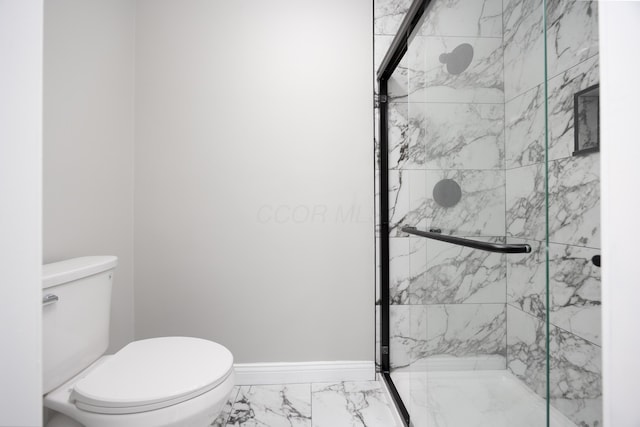 bathroom featuring toilet and a shower with shower door