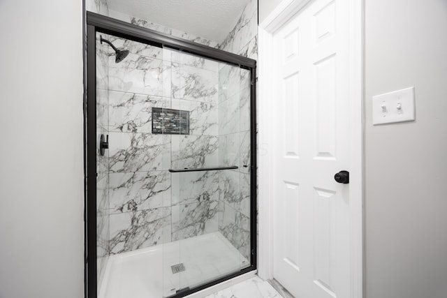 bathroom featuring a textured ceiling and walk in shower