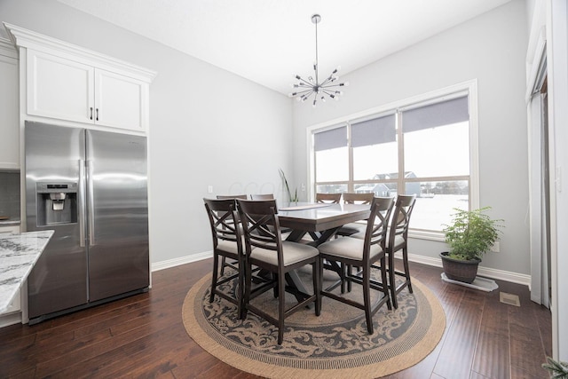 dining space featuring dark hardwood / wood-style flooring and a notable chandelier