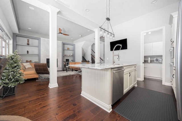 kitchen featuring light stone countertops, dishwasher, built in features, pendant lighting, and white cabinets