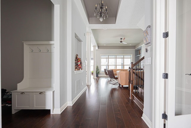 interior space featuring dark wood-type flooring and ceiling fan with notable chandelier