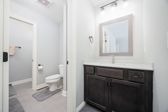 bathroom featuring a textured ceiling, vanity, and toilet